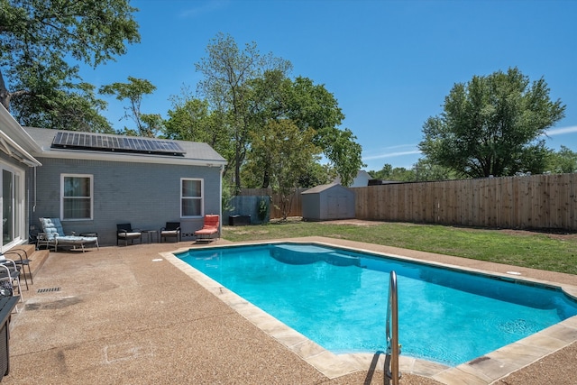 view of pool featuring a storage unit, a yard, and a patio area