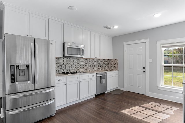 kitchen featuring white cabinetry, appliances with stainless steel finishes, dark wood-type flooring, and decorative backsplash