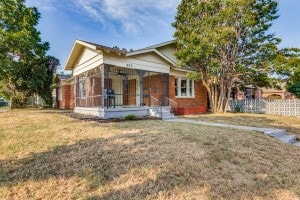 view of front of home featuring a sunroom and a front lawn