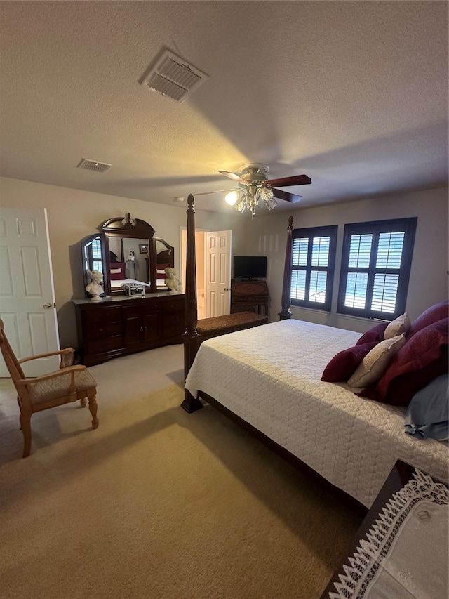 bedroom with ceiling fan, a textured ceiling, and carpet flooring