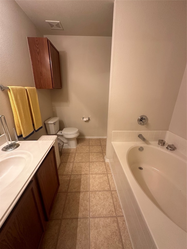 bathroom featuring tile patterned floors, a textured ceiling, vanity, a relaxing tiled tub, and toilet