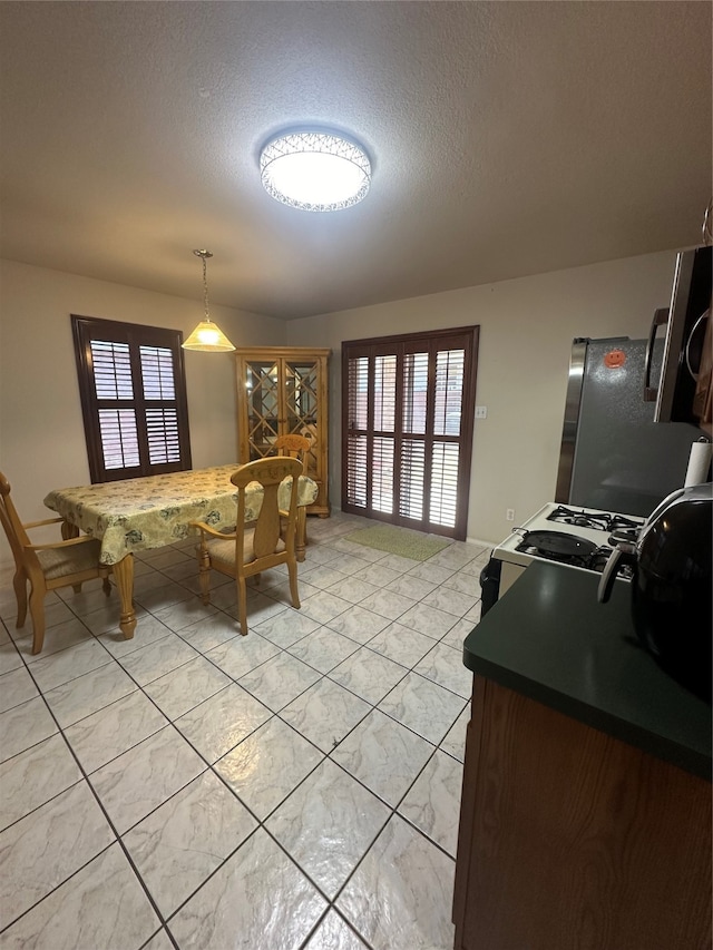 tiled dining room with a textured ceiling