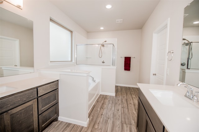 bathroom with plus walk in shower, vanity, and wood-type flooring