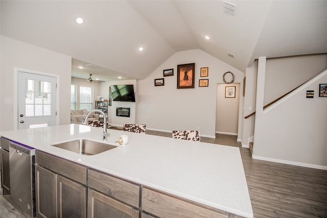 kitchen with ceiling fan, stainless steel dishwasher, dark wood-type flooring, a kitchen island with sink, and sink