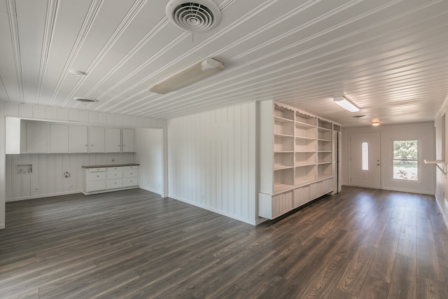 interior space with built in shelves and dark hardwood / wood-style floors