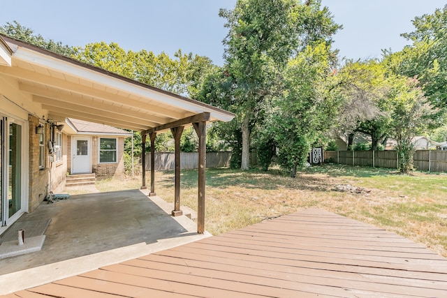 wooden terrace with a patio and a yard