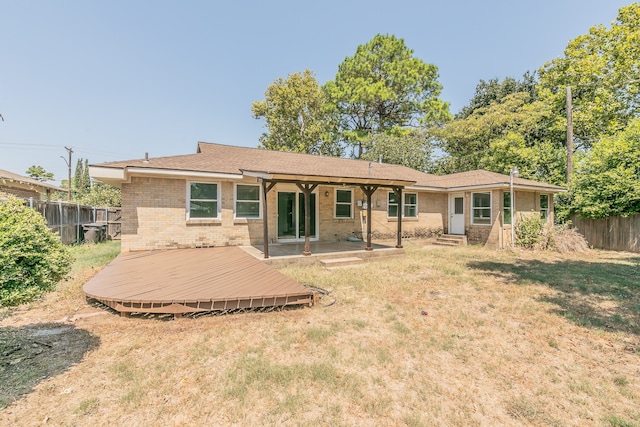 back of property with a wooden deck and a lawn