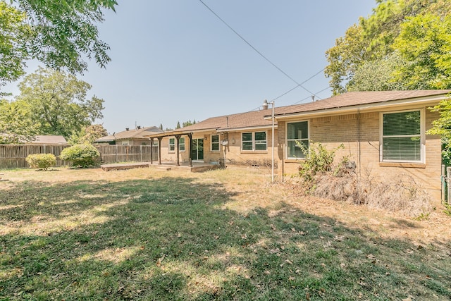 rear view of property featuring a yard