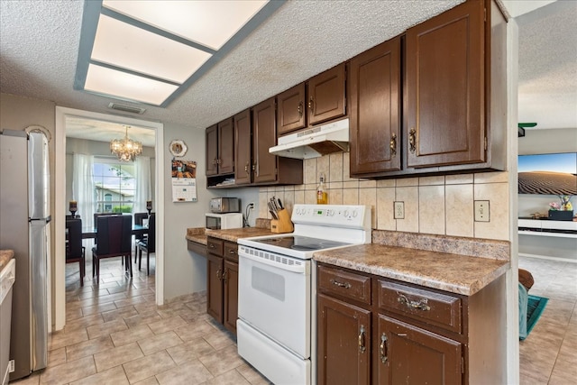 kitchen featuring light tile patterned flooring, backsplash, white electric range oven, a notable chandelier, and a textured ceiling