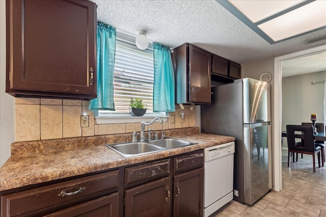 kitchen with sink, dark brown cabinetry, dishwasher, and light tile patterned floors