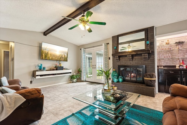 tiled living room with a fireplace, ceiling fan, vaulted ceiling with beams, and french doors