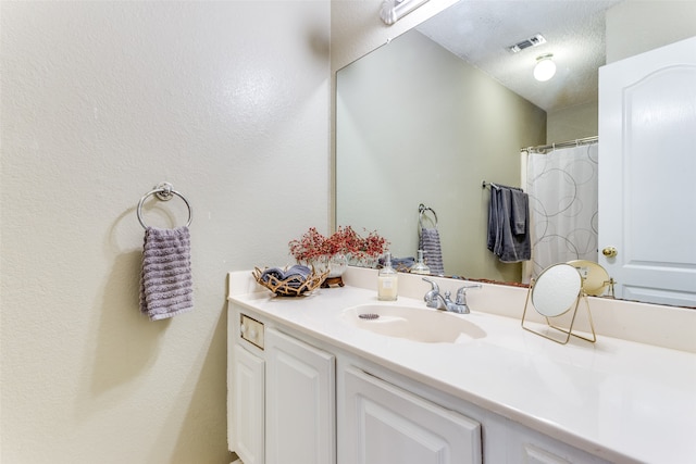 bathroom with a textured ceiling and vanity