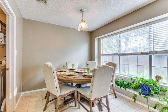 dining space featuring a textured ceiling, a healthy amount of sunlight, and light tile patterned floors