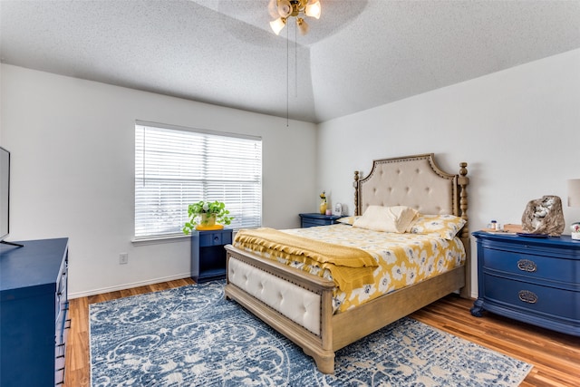 bedroom featuring dark hardwood / wood-style flooring, a textured ceiling, and ceiling fan