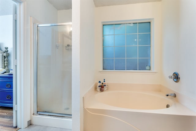 bathroom with hardwood / wood-style flooring and separate shower and tub