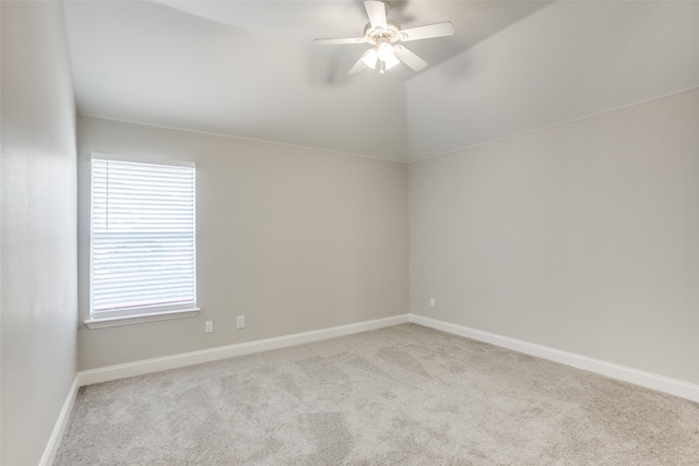 carpeted spare room featuring ceiling fan and lofted ceiling