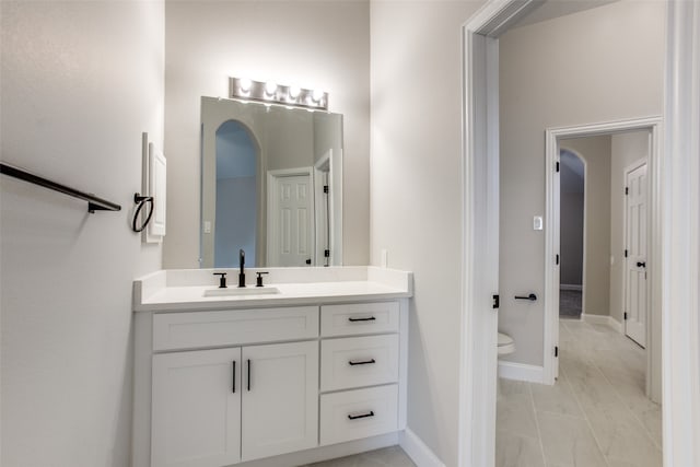 bathroom featuring tile patterned flooring, toilet, and vanity