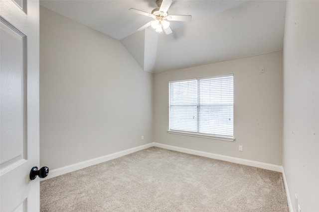 carpeted spare room featuring ceiling fan and vaulted ceiling