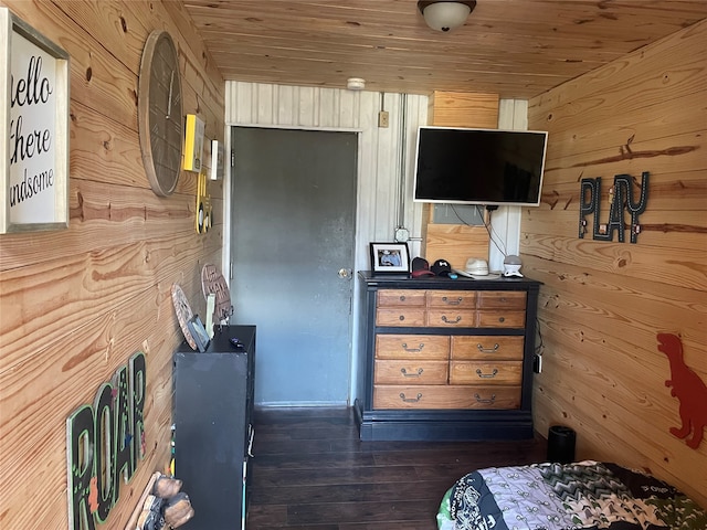 bedroom featuring wood walls, wooden ceiling, and dark wood-type flooring