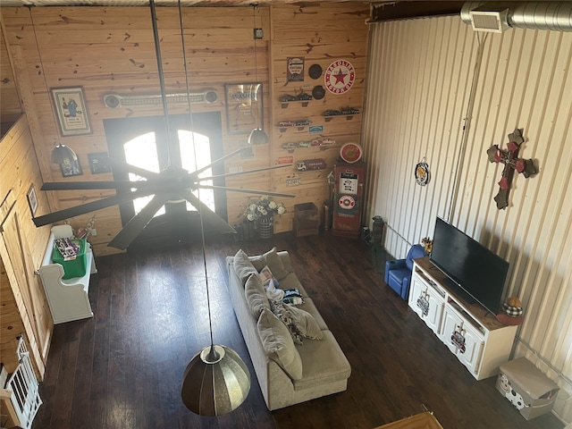 living room featuring dark hardwood / wood-style flooring and wood walls