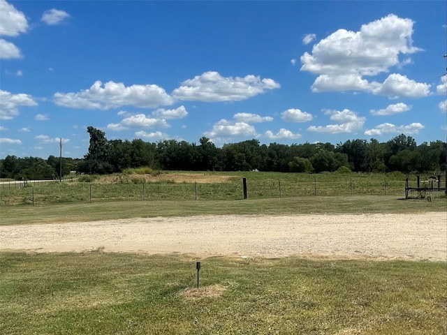 view of community featuring a rural view and a yard