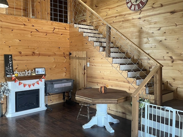 stairway with wood-type flooring, a towering ceiling, wooden ceiling, and wood walls