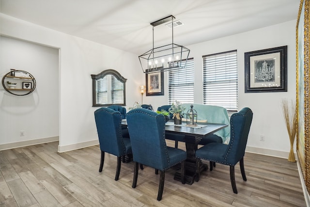 dining area with a chandelier and light wood-type flooring