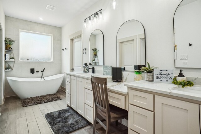 bathroom with a tub and vanity