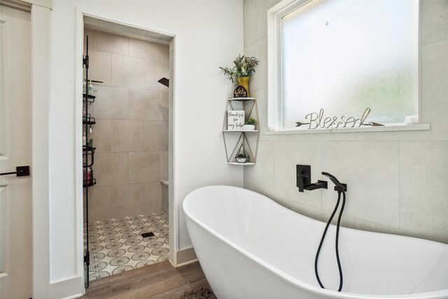 bathroom featuring hardwood / wood-style flooring and separate shower and tub