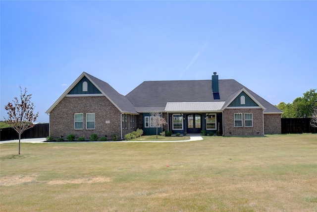 craftsman house with brick siding, fence, a chimney, and a front lawn