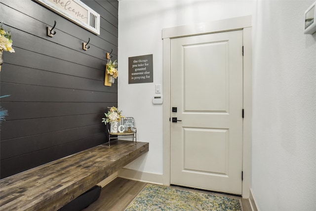 mudroom featuring hardwood / wood-style floors and wood walls