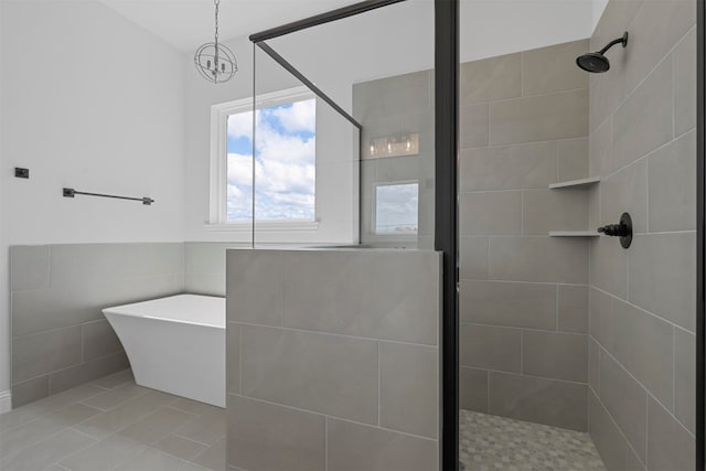 bathroom featuring tile patterned floors, a tile shower, and tile walls