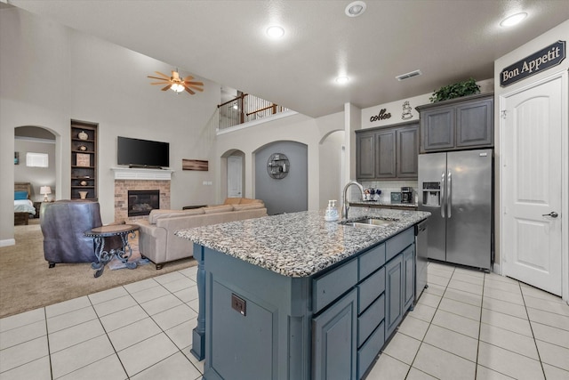 kitchen featuring visible vents, a sink, arched walkways, appliances with stainless steel finishes, and light tile patterned floors