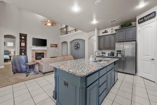 kitchen with a sink, appliances with stainless steel finishes, visible vents, ceiling fan, and arched walkways