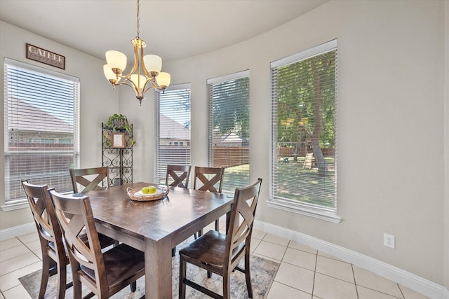 dining area featuring a notable chandelier, light tile patterned flooring, and baseboards