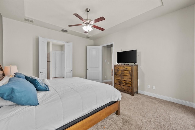 bedroom featuring visible vents, light colored carpet, a ceiling fan, and baseboards