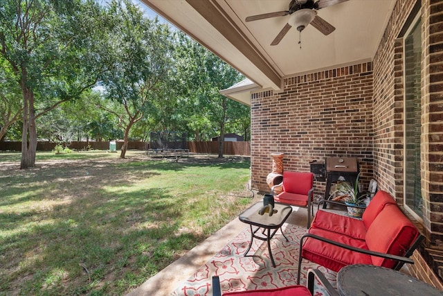 view of patio featuring a trampoline, a ceiling fan, a fenced backyard, and grilling area