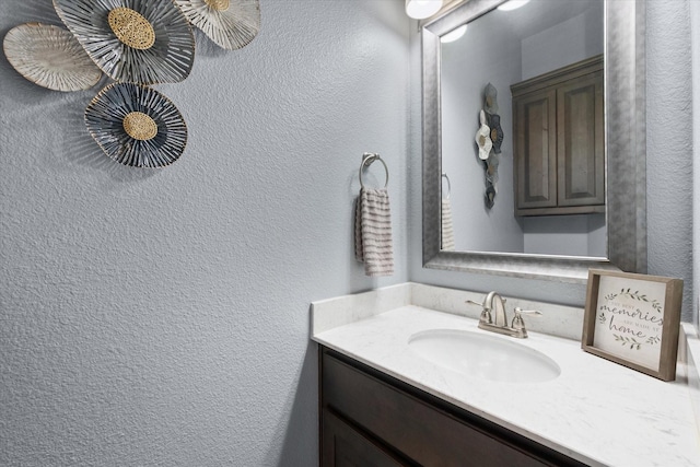 bathroom featuring a textured wall and vanity