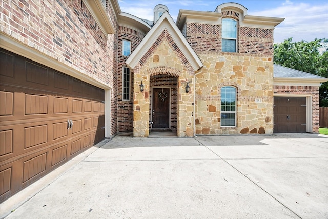 view of front of home featuring concrete driveway, a shingled roof, brick siding, and stone siding