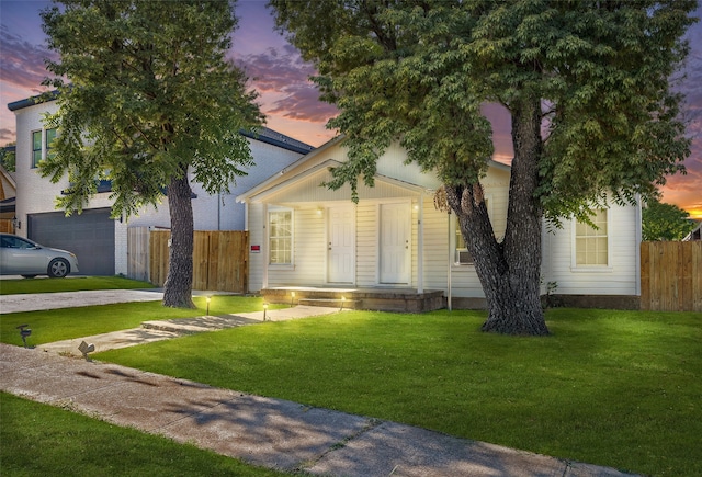 view of front of house featuring a garage and a lawn