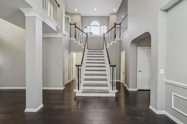 stairway with a high ceiling and hardwood / wood-style flooring