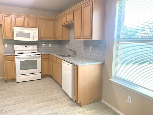 kitchen with white appliances, tasteful backsplash, light hardwood / wood-style flooring, and sink