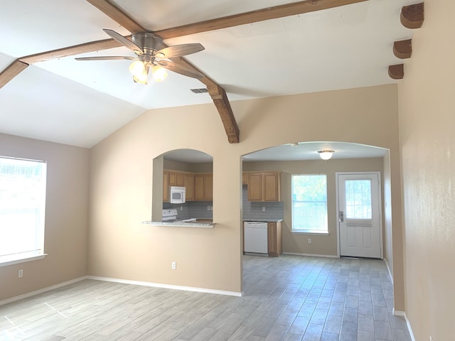 unfurnished living room with vaulted ceiling with beams, a healthy amount of sunlight, light hardwood / wood-style floors, and ceiling fan