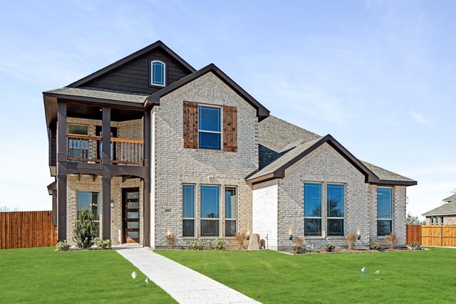 view of front facade featuring a balcony and a front lawn