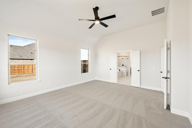 interior space with lofted ceiling, light colored carpet, and ceiling fan