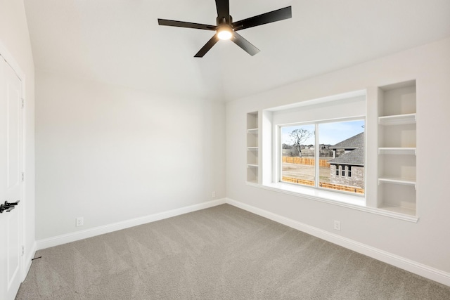 carpeted spare room with built in features and ceiling fan