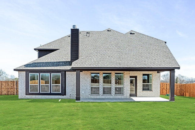 back of house with a yard and a patio