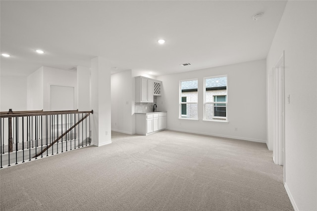 spare room with light colored carpet and sink