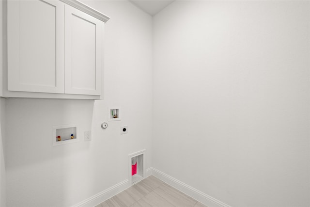 laundry room with hookup for an electric dryer, hookup for a washing machine, hookup for a gas dryer, and cabinets