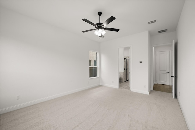 unfurnished bedroom with ensuite bath, ceiling fan, and light carpet